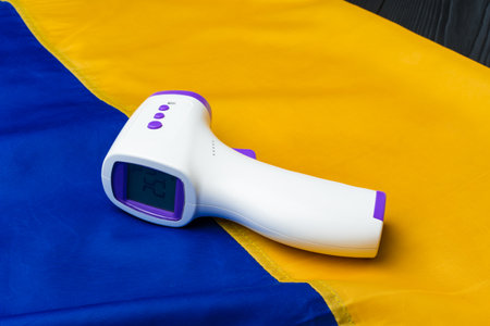 Contactless thermometer on the flag of Ukraine