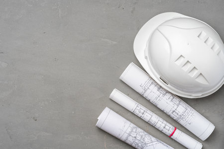 Hardhat and blueprints on wooden background top viewの写真素材