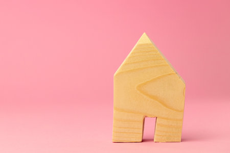 Wooden house miniature on pink background close upの写真素材