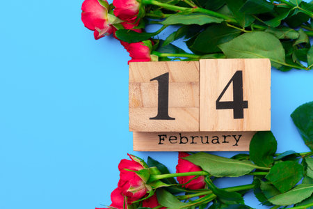 Wooden calendar and roses on blue background