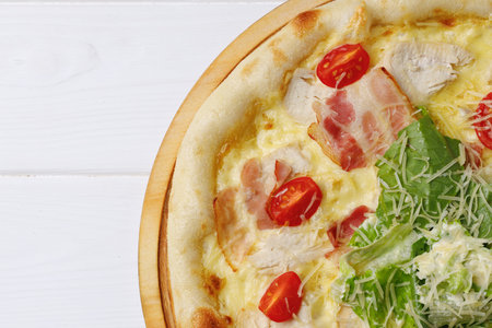 Caesar pizza on board on white wooden tableの写真素材