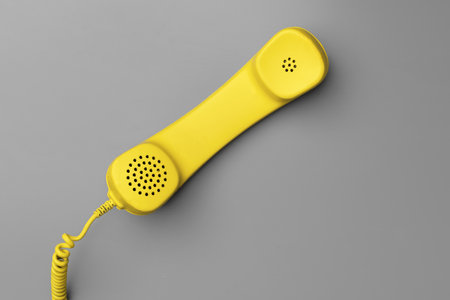 Yellow .landline phone on gray background top viewの写真素材