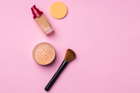 Complexion make up products and brush on pink backgroundの写真素材