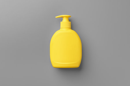Yellow cosmetic container on gray background top viewの写真素材