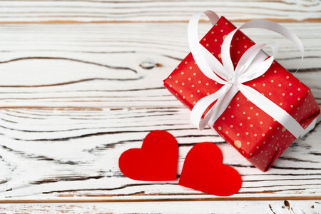 Wrapped gift for Valentines day on wooden tableの写真素材