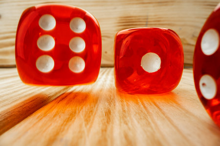 Red dice tossed on wooden background close upの写真素材
