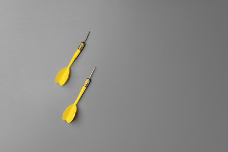 Yellow dart arrow on gray background copy spaceの写真素材