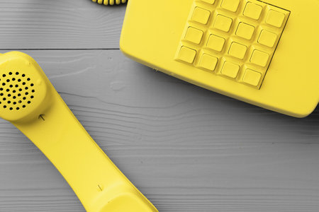 Yellow .landline phone on gray background top viewの写真素材