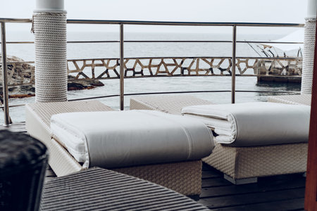 White sunbed loungers on terrace near sea