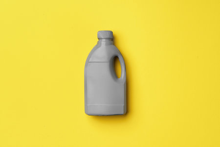 Gray container of lliquid detergents on yellow backgroundの写真素材