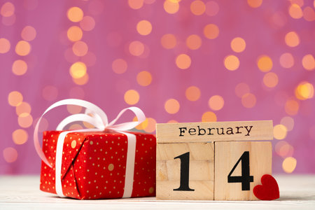 Wooden calendar 14th of February on pink bokeh backgroundの写真素材