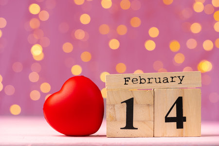Wooden calendar 14th of February on pink bokeh backgroundの写真素材
