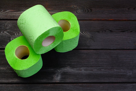 Green toilet paper rolls on black wooden backgroundの写真素材