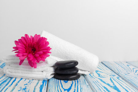 clean soft towels with flower on wooden tableの写真素材