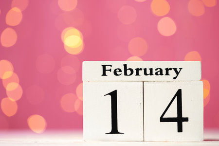 Wooden calendar 14th of February on pink bokeh backgroundの写真素材