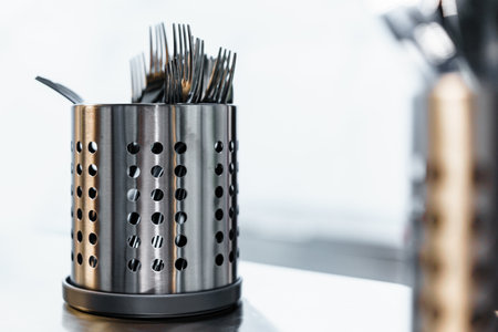 Metal cutlery drainers in a professional kitchen in a restaurantの写真素材