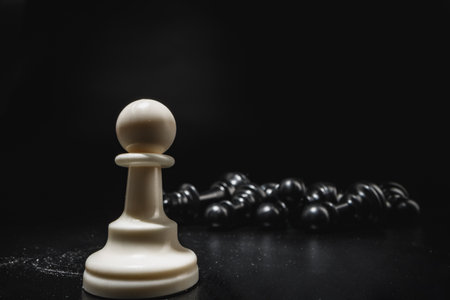 Chess game with chess pieces against black backgroundの写真素材