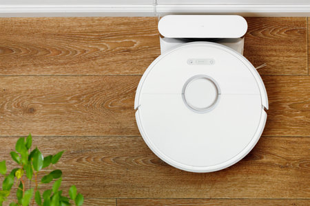 White robotic vacuum cleaner on wooden floor