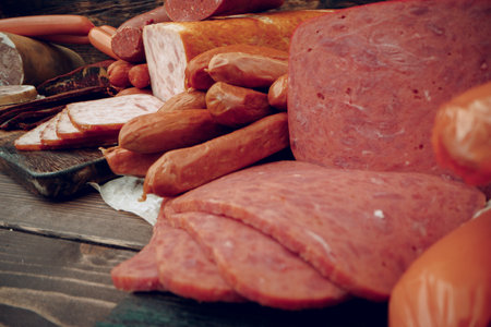 Assortment of different sausages laid out on brown wooden background