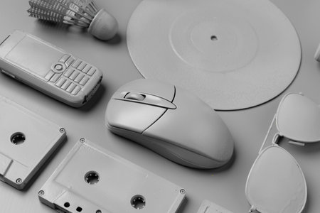 Gray cassettes, computer mouse, disc and mobile phone on gray backgroundの写真素材