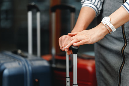 Unrecognizable businesswoman standing with travel bag close upの写真素材