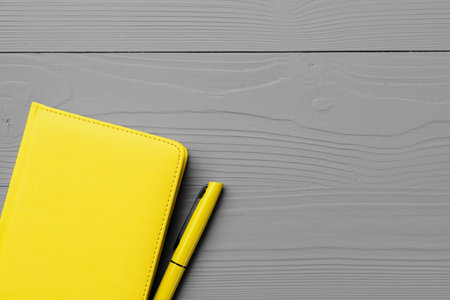 Yellow notepad on gray wooden background top viewの写真素材