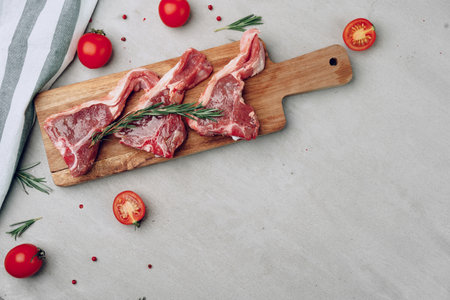 Raw t-bone steak on wooden cutting board on wooden table