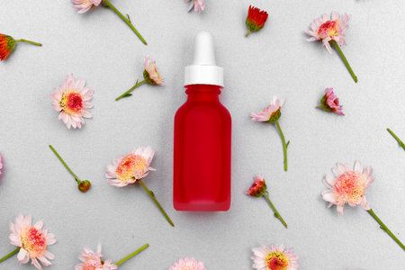 Cosmetic oil bottle on floral buds backgroundの写真素材