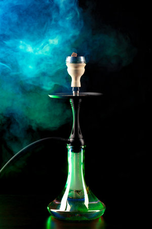 Smoking hookah on black background with color fog