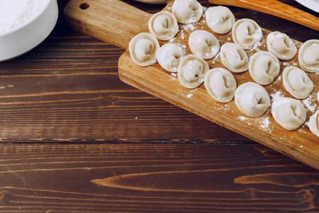 Raw stuffed russian dumplings on wooden boardの写真素材