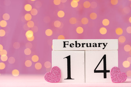 Wooden calendar 14th of February on pink bokeh backgroundの写真素材