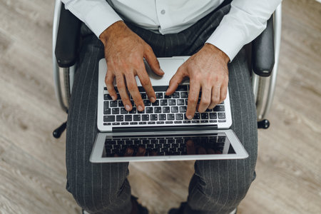 Disabled man in a wheelchair using laptop