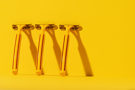 Disposable razors on yellow background, studio shotの写真素材