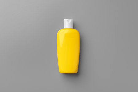 Yellow cosmetic container on gray background top viewの写真素材