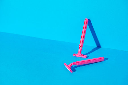 Disposable razors on blue background, studio shot