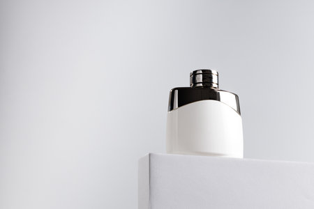 Fragrance bottle on gray block against gray backgroundの写真素材