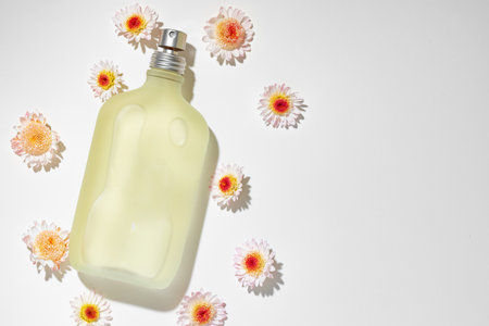 Bottle of fragrance surrounded by flower budsの写真素材