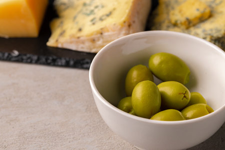 Close up of bowl with green olives on tableの写真素材
