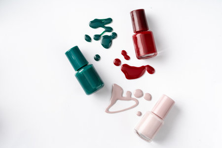 Bright colored nail polish bottles with drippings on white backgroundの写真素材