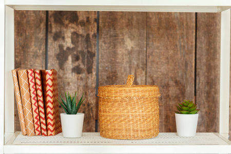 Stylish white bookshelf against grunge wooden wallの写真素材
