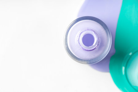 Pastel color spilled nail polish bottles over whiteの写真素材