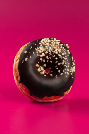 Yummy glazed round donut on a bright pink backgroundの写真素材