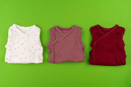Top view of baby clothes on green backgroundの写真素材
