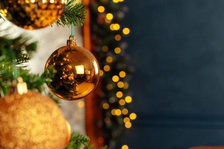 Beautiful golden bauble hanging from a Christmas treeの写真素材