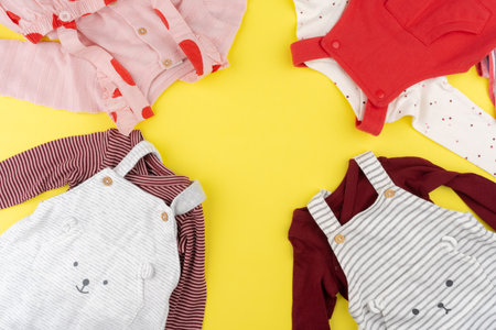 Top view of baby girl clothes on yellow backgroundの写真素材