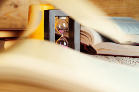 Close up of book page on a background of hourglassの写真素材