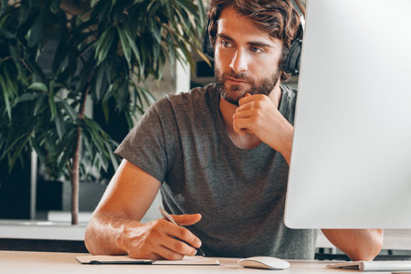 Bearded young businessman working at modern officeの写真素材