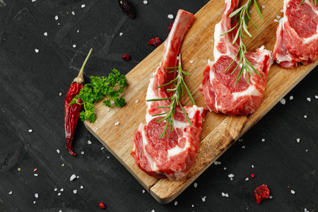 Racks of lamb ready for cooking on dark backgroundの写真素材