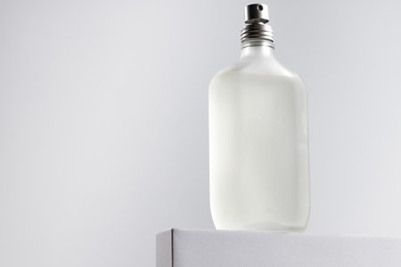 Fragrance bottle on gray block against gray backgroundの写真素材