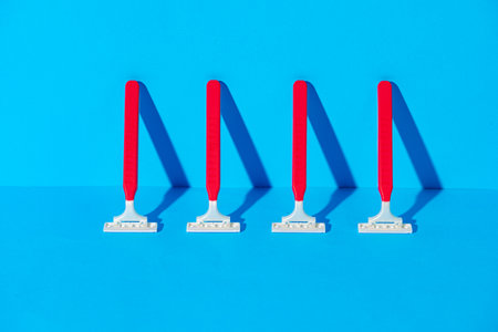 Disposable razors on blue background, studio shotの写真素材